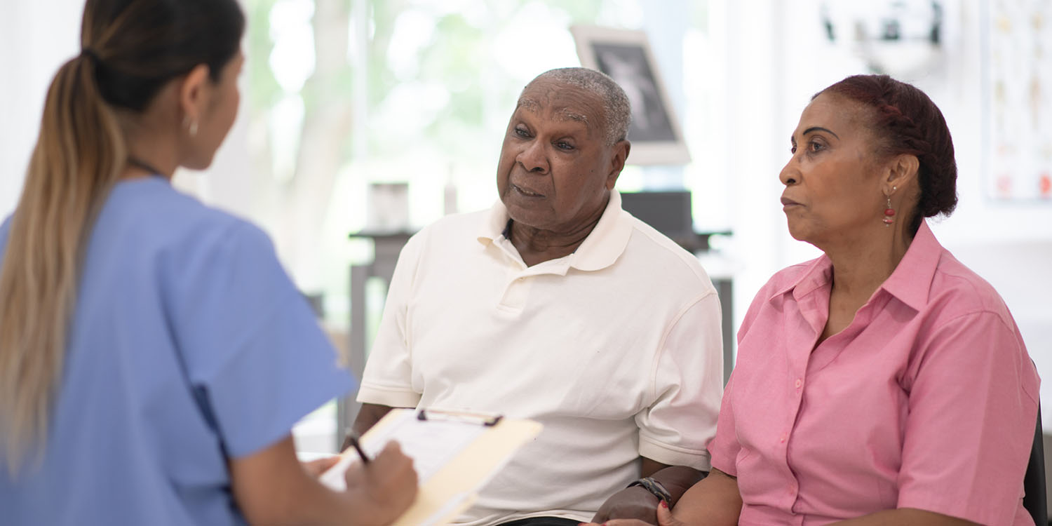 A Black senior couple sits down and speaks with the doctor about a prostate cancer diagnosis